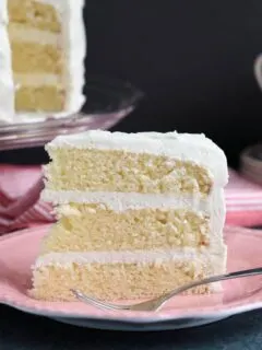 a slice of vanilla buttermilk layer cake on a pink plate