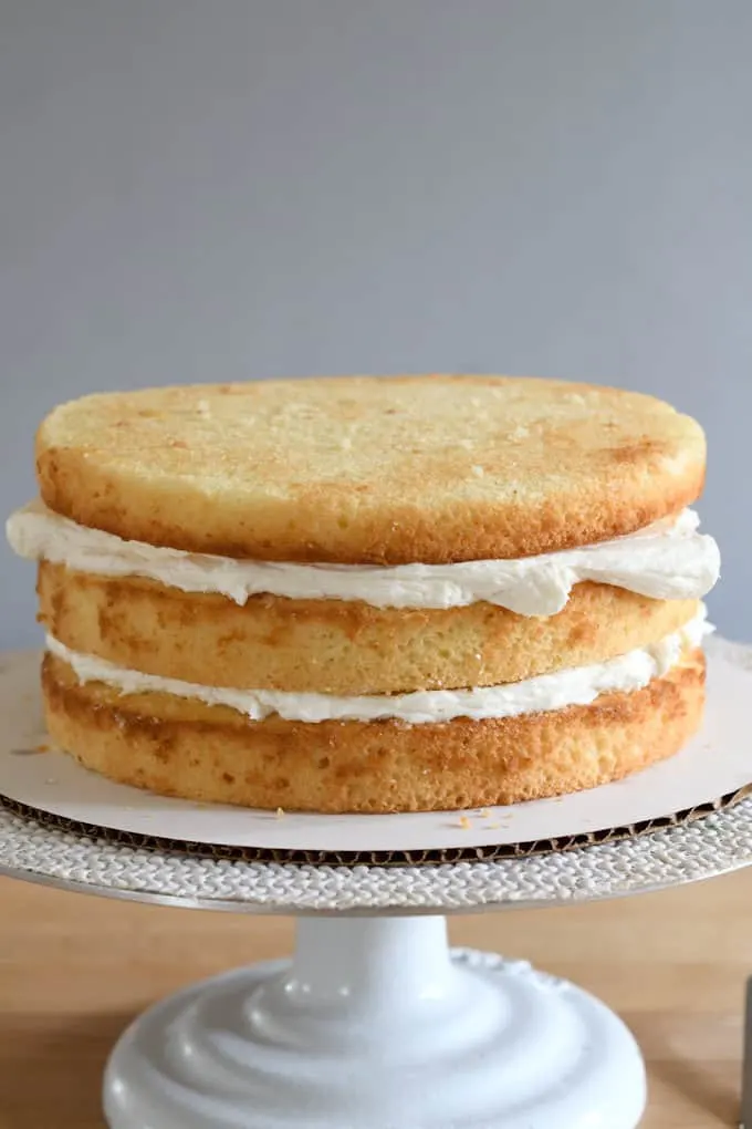 an uniced vanilla buttermilk cake on a cake stand