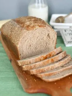 a slices loaf of sourdough whole wheat bread on a cutting board