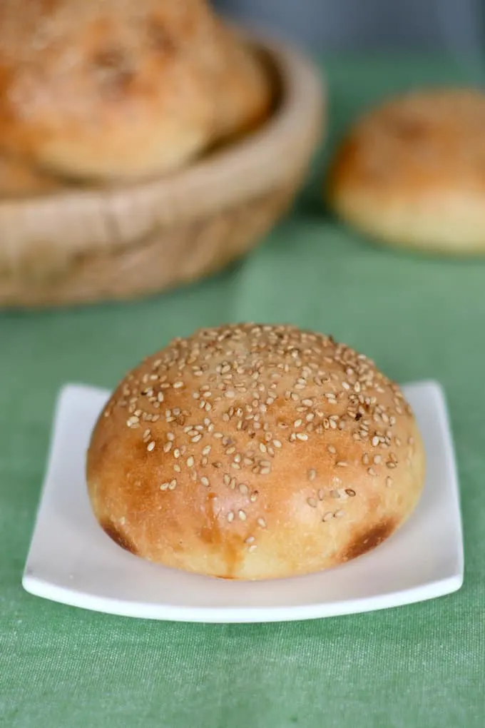 a sesame seed sourdough hamburger bun on a plate