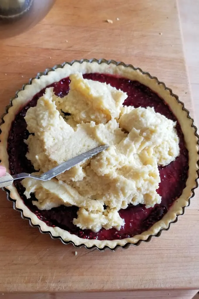 a photo showing how to spread the filling into a bakewell tart