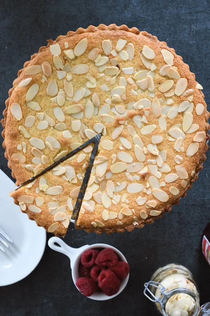 a top view of a bakewell tart with one slice cut