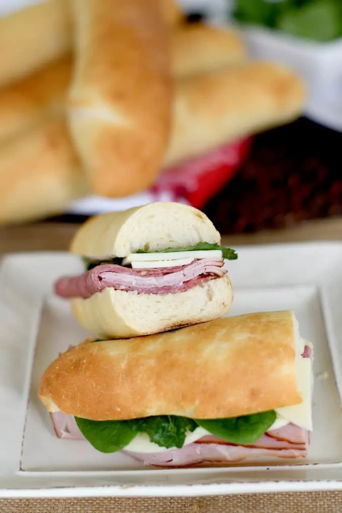 A submarine sandwich cut in two pieces and stacked on a plate