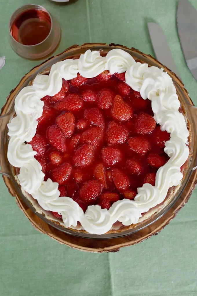 An overhead view of a fresh fresh strawberry pie with whipped cream border.