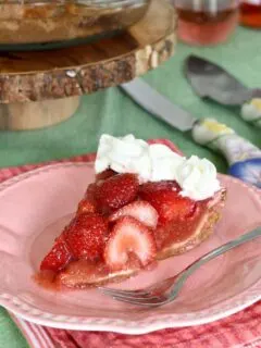 a slice of fresh strawberry pie on a pink plate