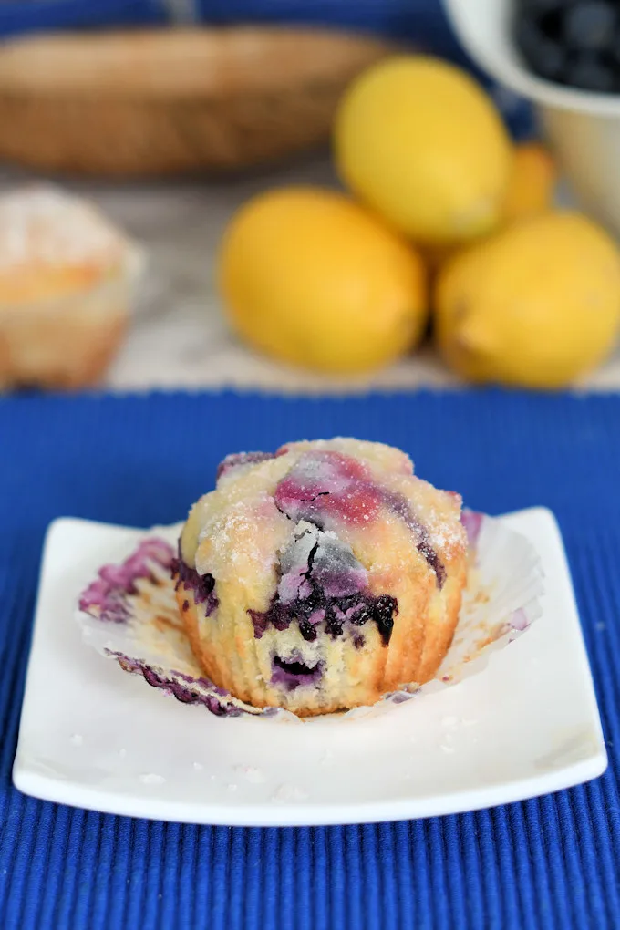 an unwrapped lemon blueberry muffin on a plate