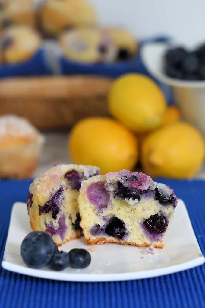 a blueberry muffin cut in half on a plate