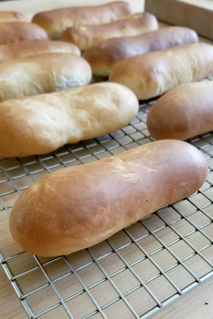 freshly baked homemade hot dog buns cooling on a wire rack