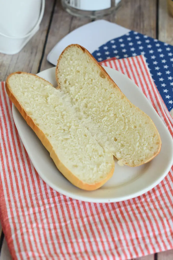 a sliced hot dog bun on a plate to show the interior crumb