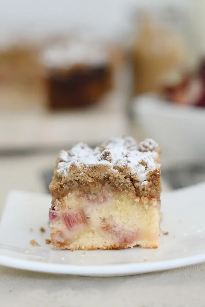a piece of rhubarb crumb cake on a small white plate