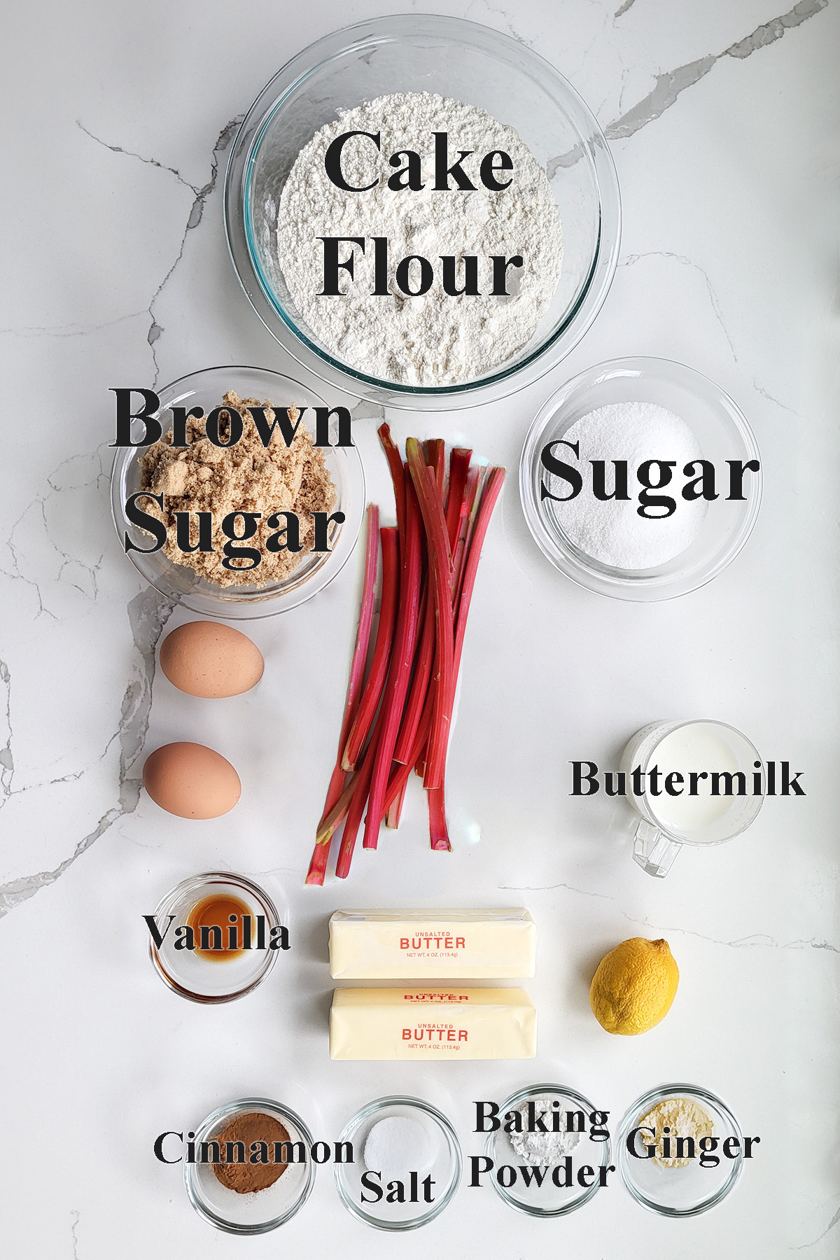 ingredients for rhubarb crumb cake in glass bowls on a white surface.