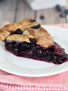a slice of blueberry pie in a white plate