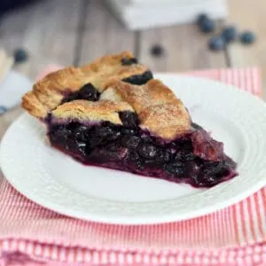 a slice of blueberry pie in a white plate