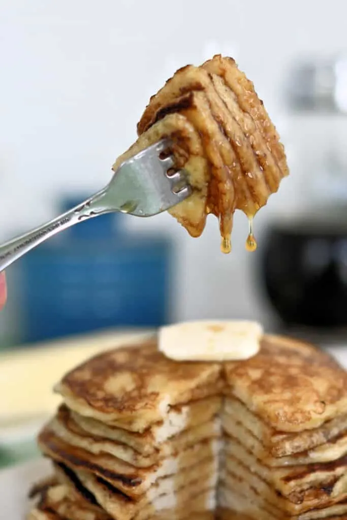a forkful of sourdough pancakes with syrup dripping off