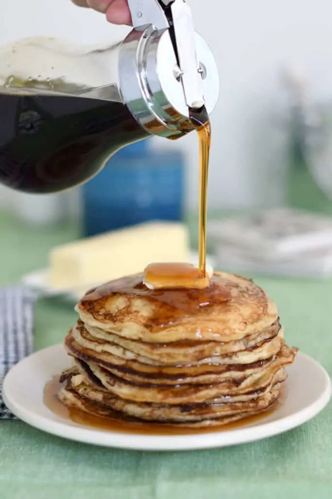 a stack of sourdough pancakes with syrup pouring over the stack