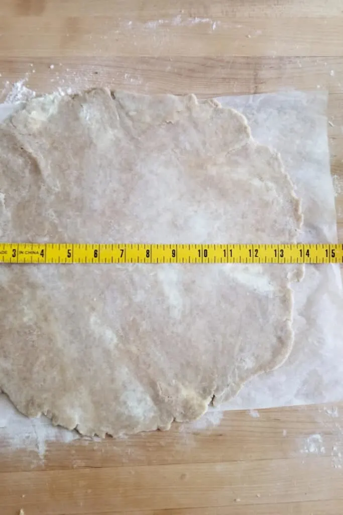 whole wheat pie dough rolled out on a piece of parchment paper