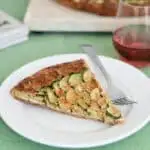 a slice of zucchini galette in a whole wheat pie crust on a plate