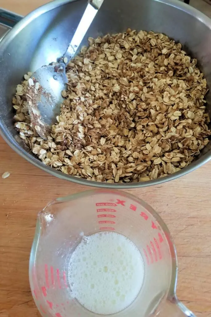 a bowl of granola ingredients and a measuring cup with egg whites