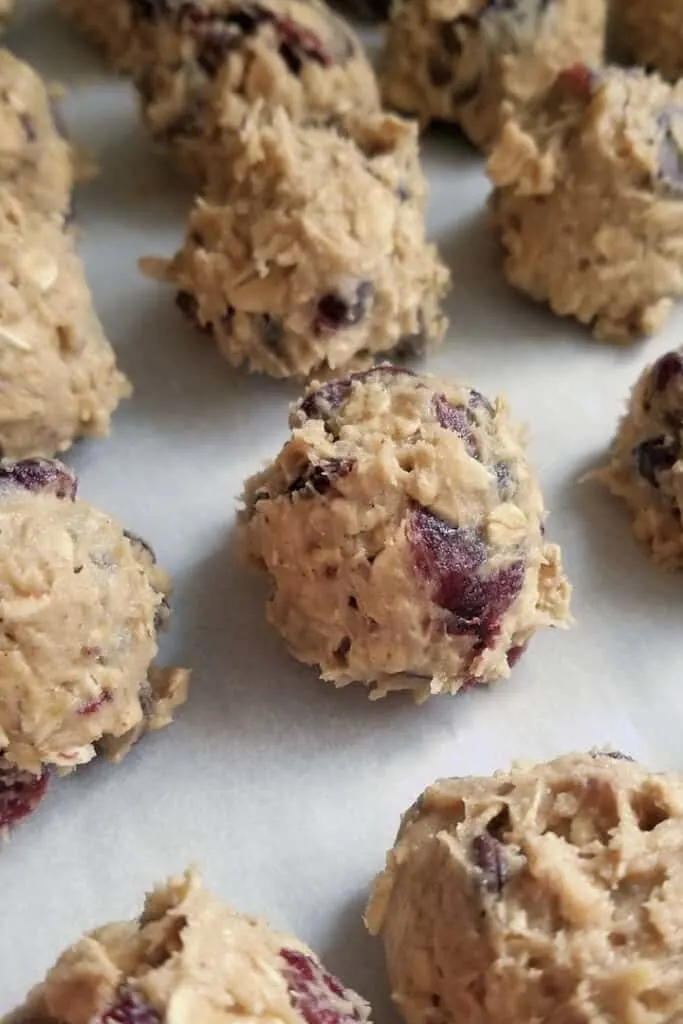 a parchment lined cookie sheet with unbaked cookie dough balls