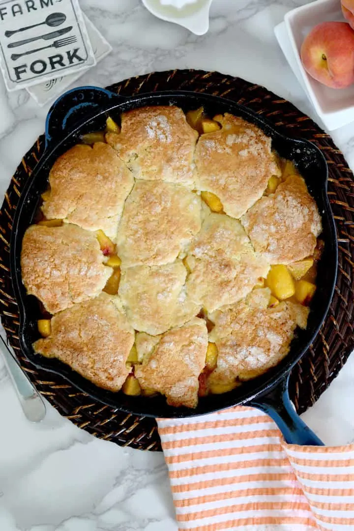a cast iron skillet filled with fresh peach cobbler