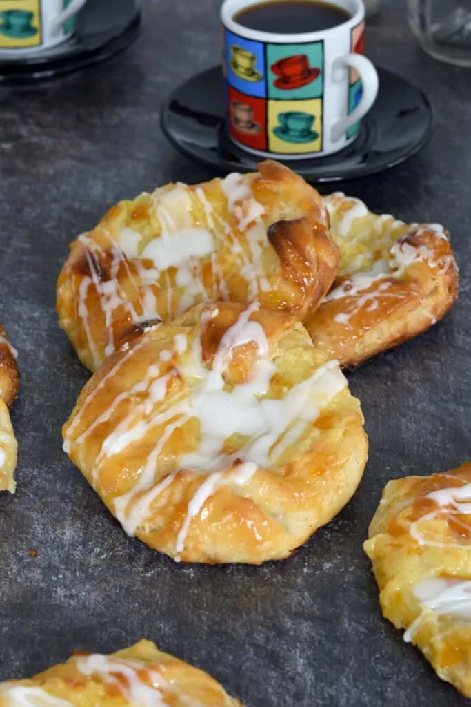 a stack of cheese danish with glaze on a gray surface