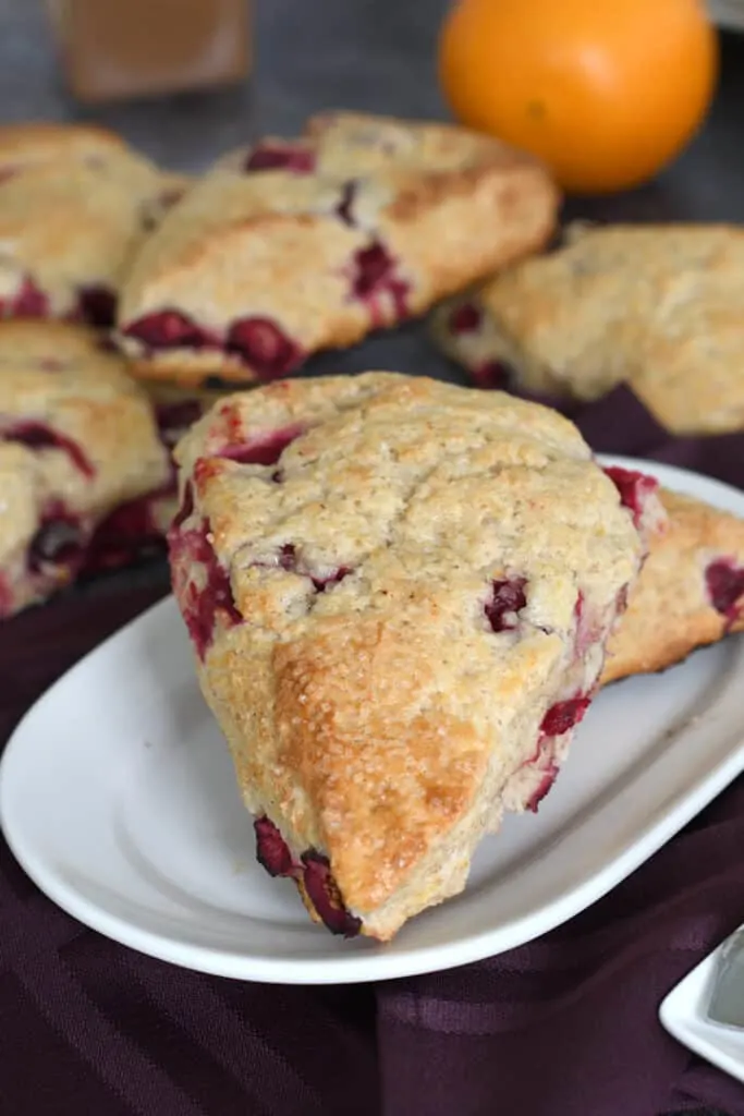 a plate stacked with cranberry orange scones