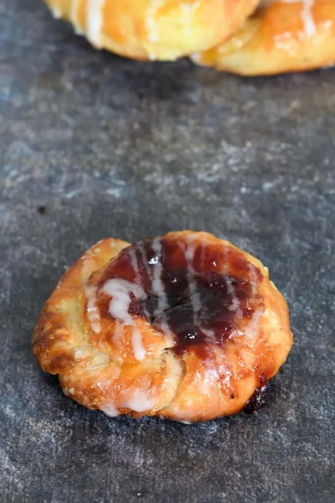 a jam filled sourdough danish on a gray background