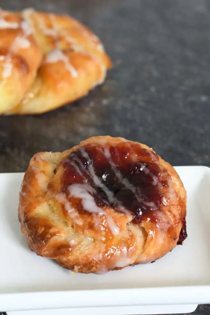 a jam filled sourdough danish pastry on a white plate