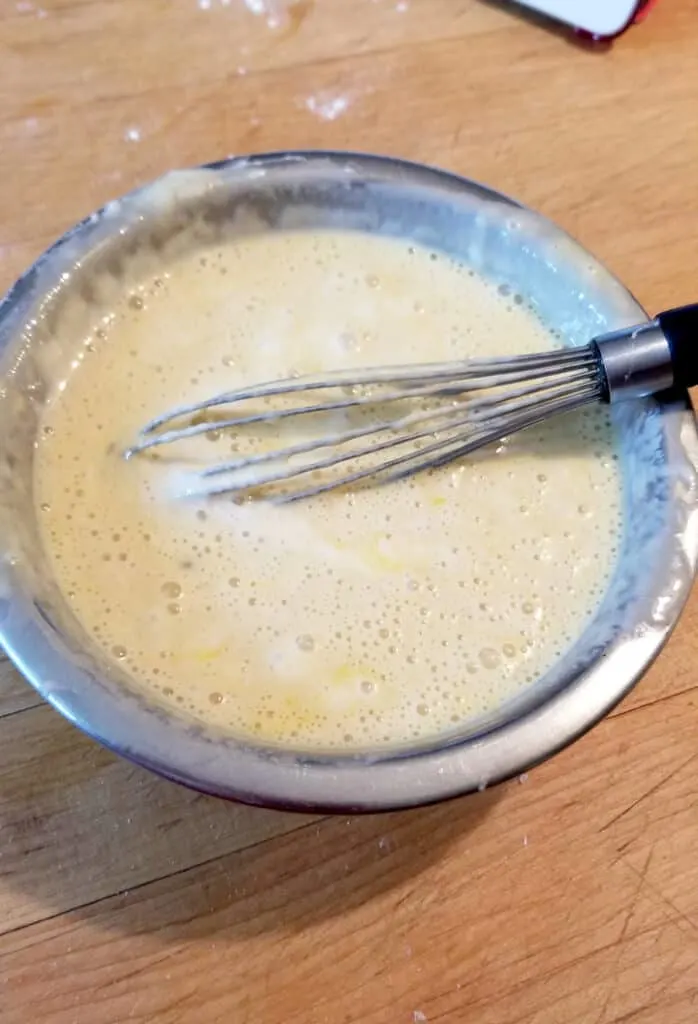 a bowl with sourdough discard whisked with eggs