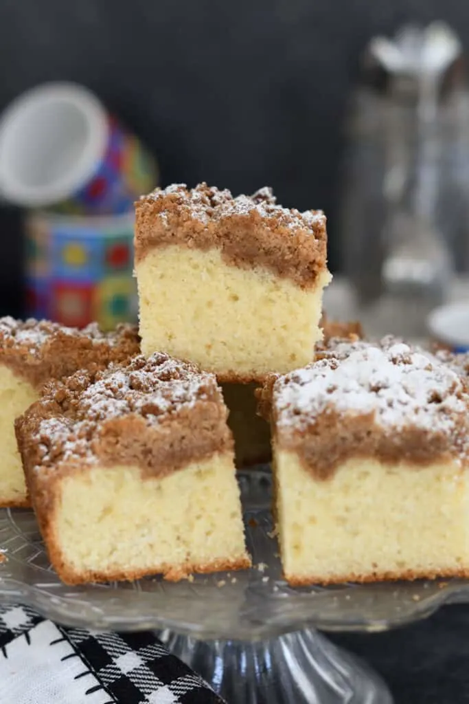 a stack of sourdough discard crumb cake slices on a cake stand