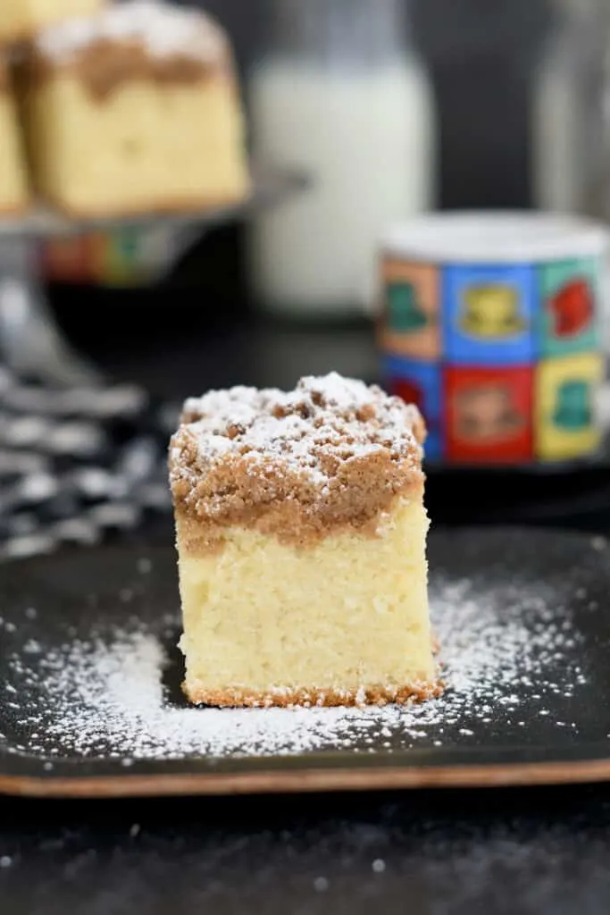 a slice of sourdough crumb cake on a black plate