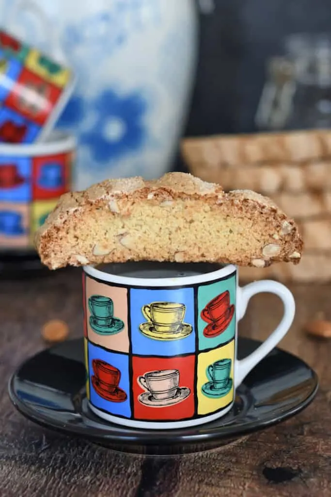a sourdough biscotti cookie sitting on top of the cup of expresso
