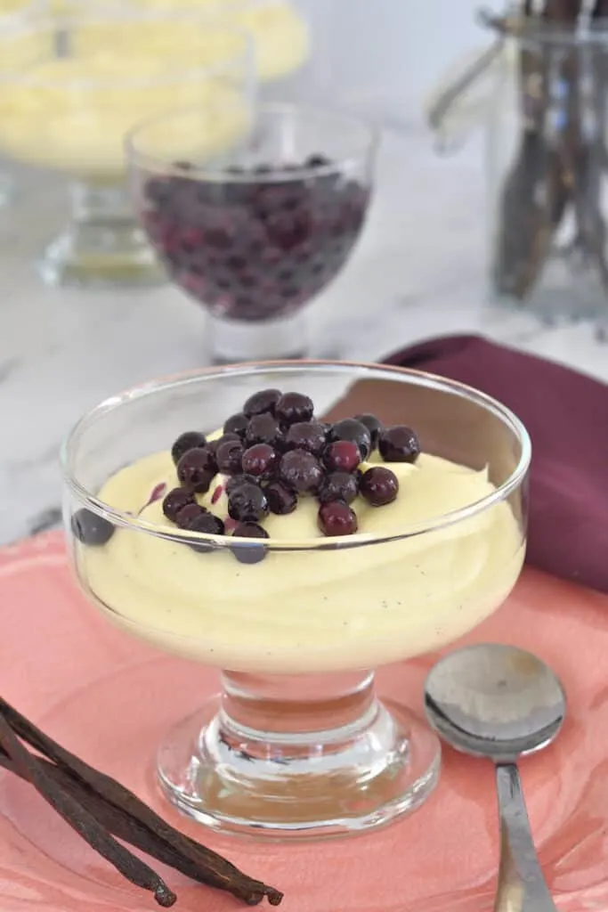 a dish of vanilla mousse topped with wild blueberries