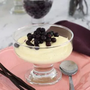 a dessert dish filled with vanilla mousse topped with wild blueberries