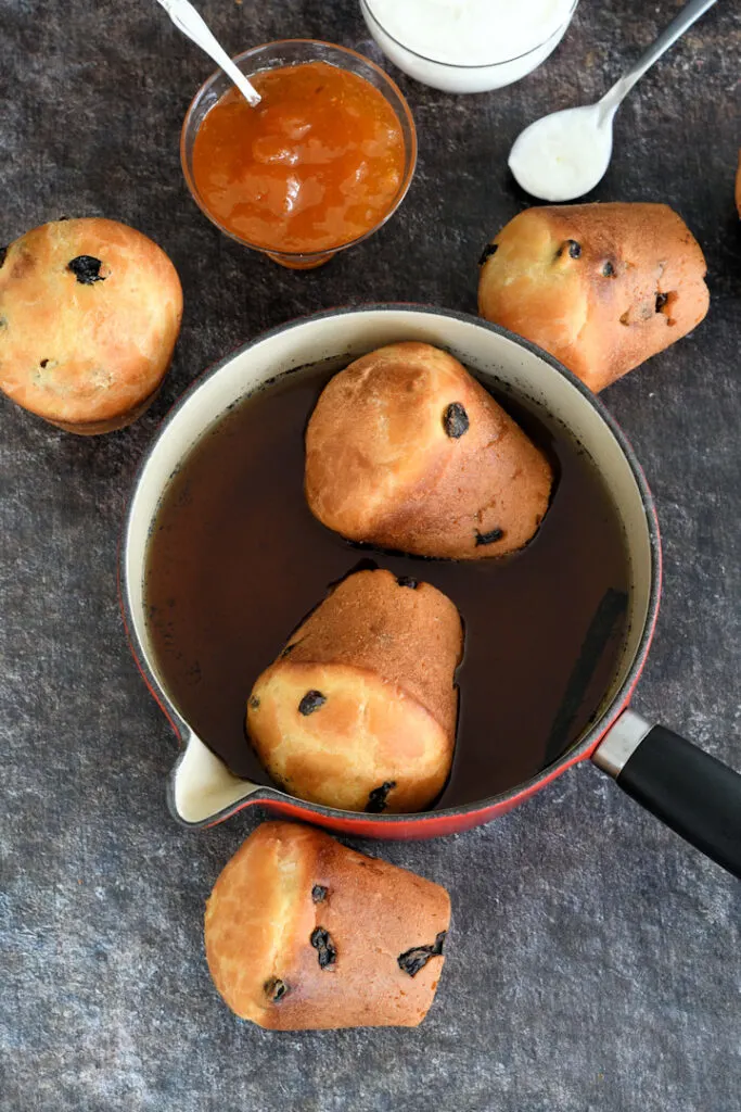 two baba pastries soaking in rum syrup.