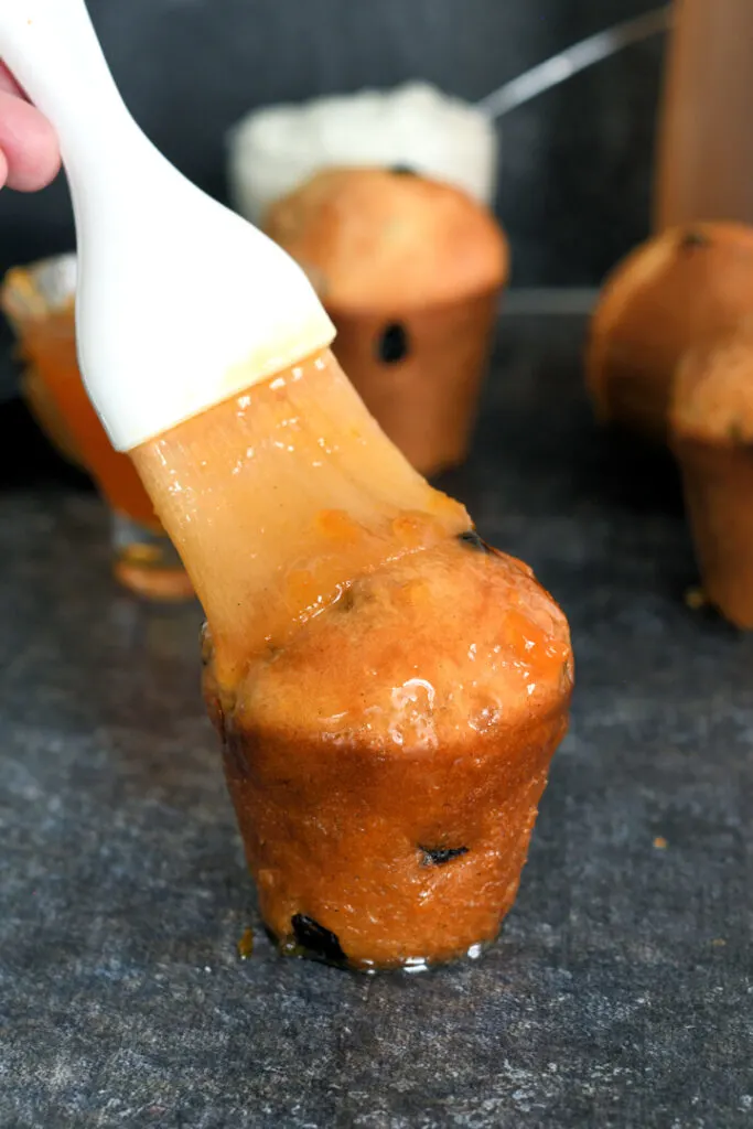 a baba au rhum being brush with apricot preserves