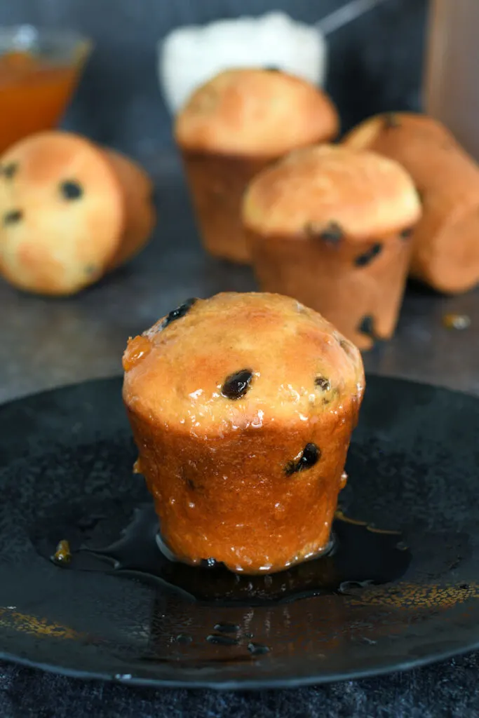 a sourdough baba au rhum on a plate in a pool of rum syrup