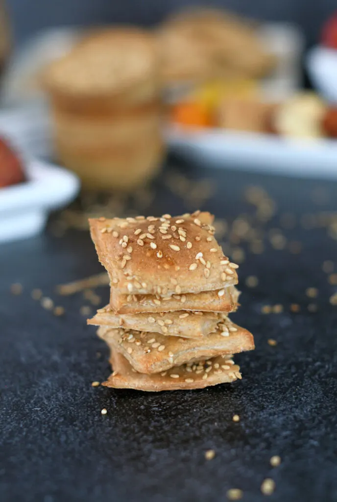a stack of sourdough crackers on a black surface
