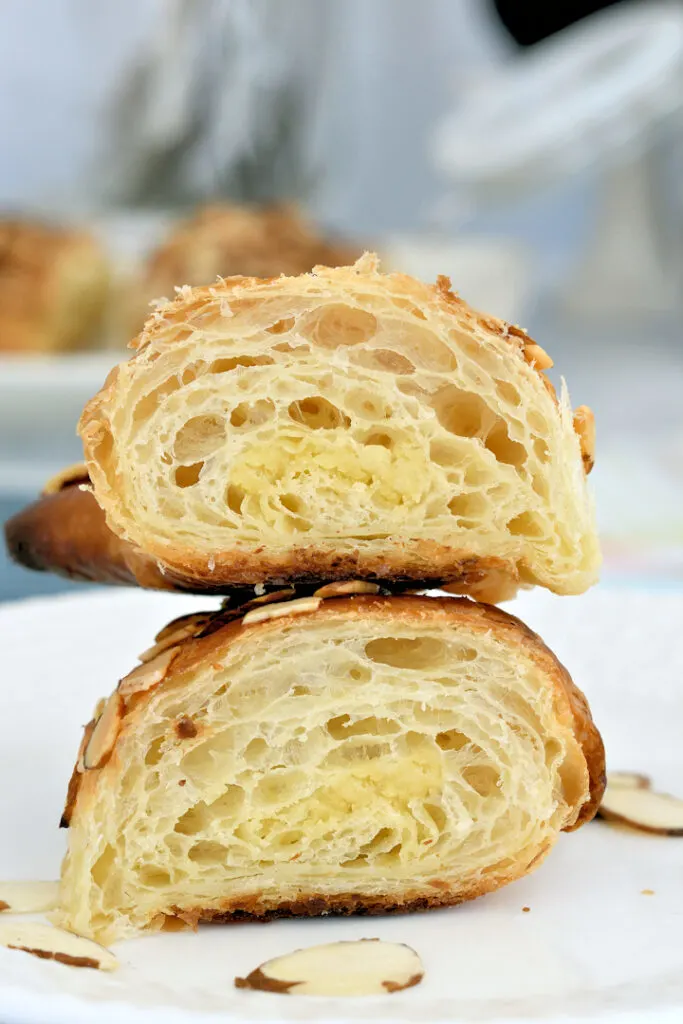 a slice almond croissant showing the layers and filling