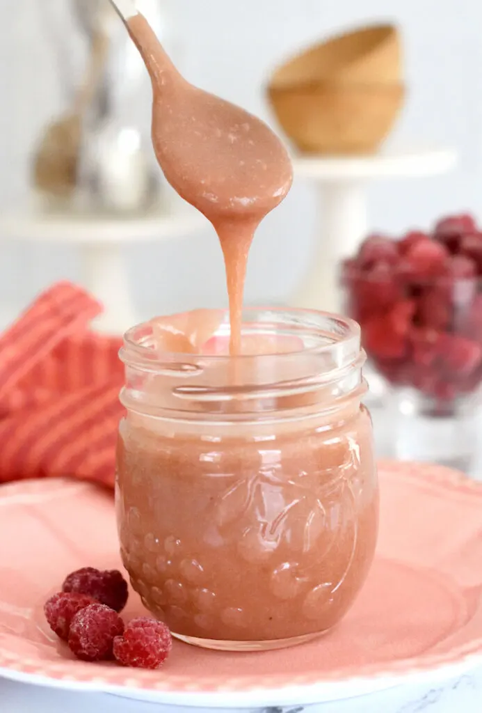 a jar of raspberry curd with a spoon