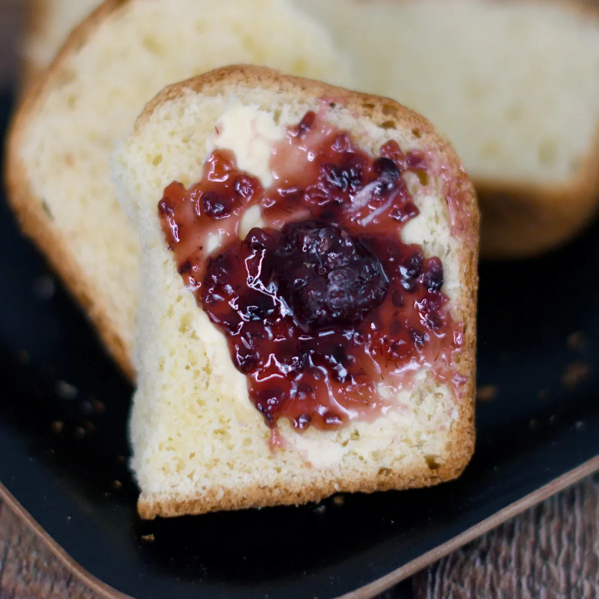 a slice of sourdough brioche topped with butter and jam