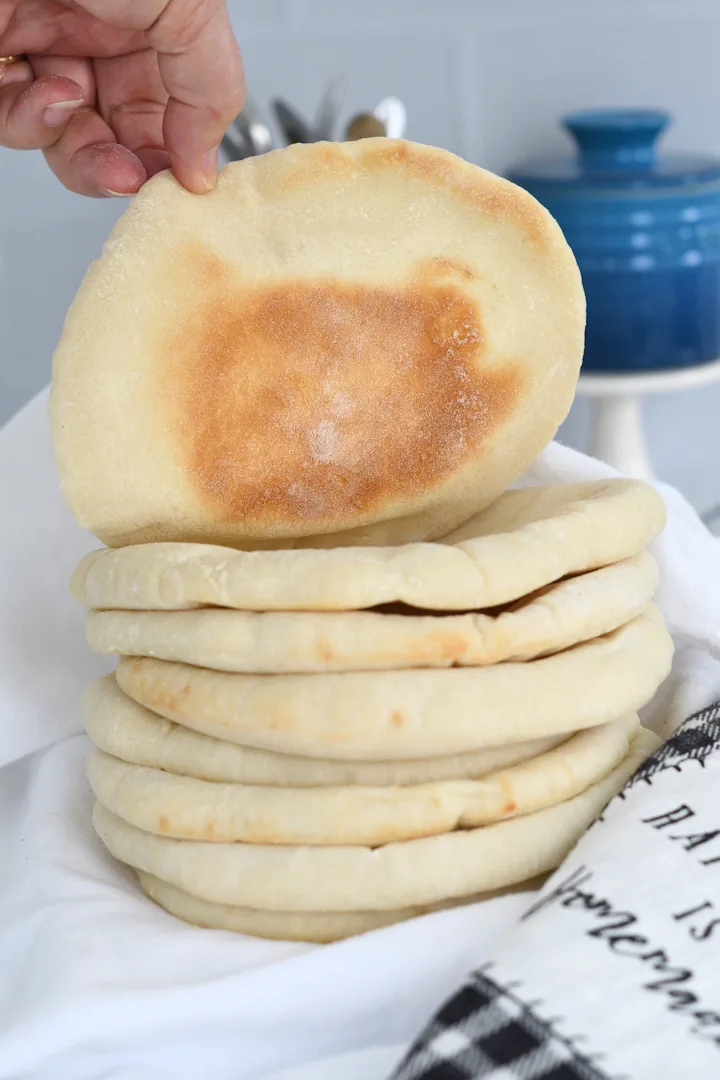 a stack of pita breads, with one showing the golden brown bottom side