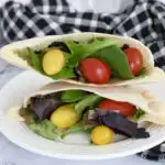 pita bread filled with lettuce and tomatoes on a plate