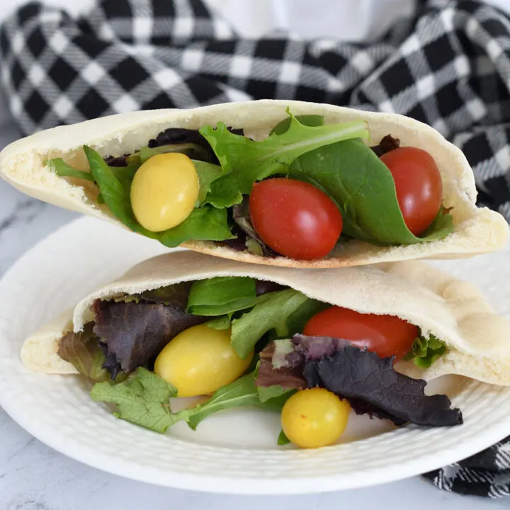 pita bread filled with lettuce and tomatoes on a plate