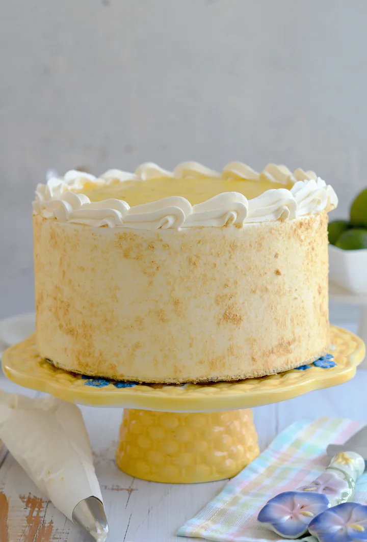 A cake pan with graham cracker crust and cheesecake batter poured in.