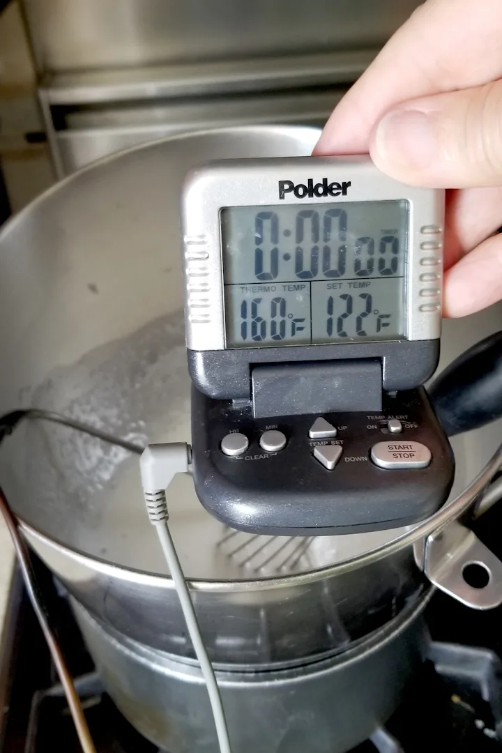 showing a bowl of egg whites and a thermometer reading 160F.