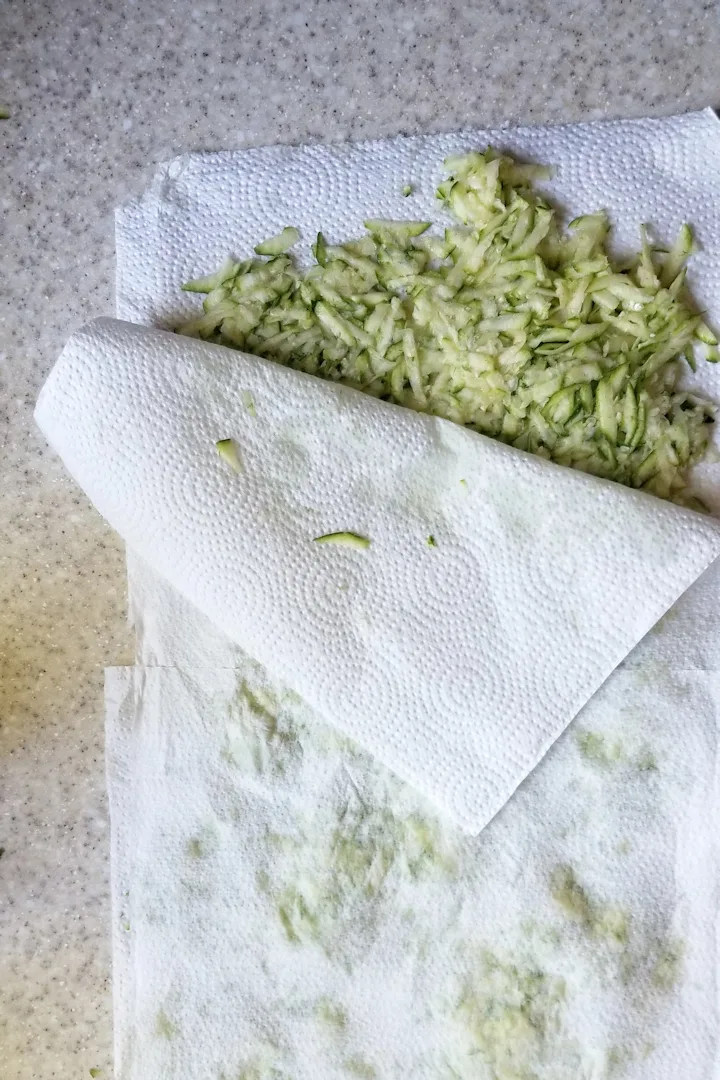 a layer of shredded zucchini between two paper towels