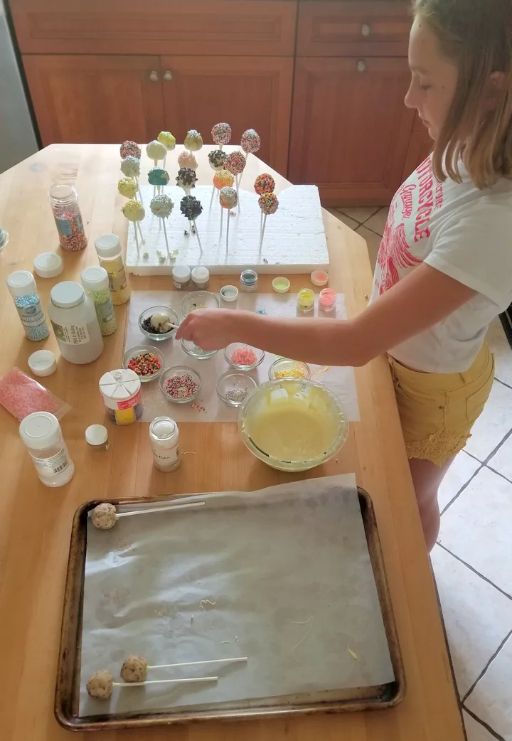 showing the setup for dipping and decorating edible cookie dough pops.