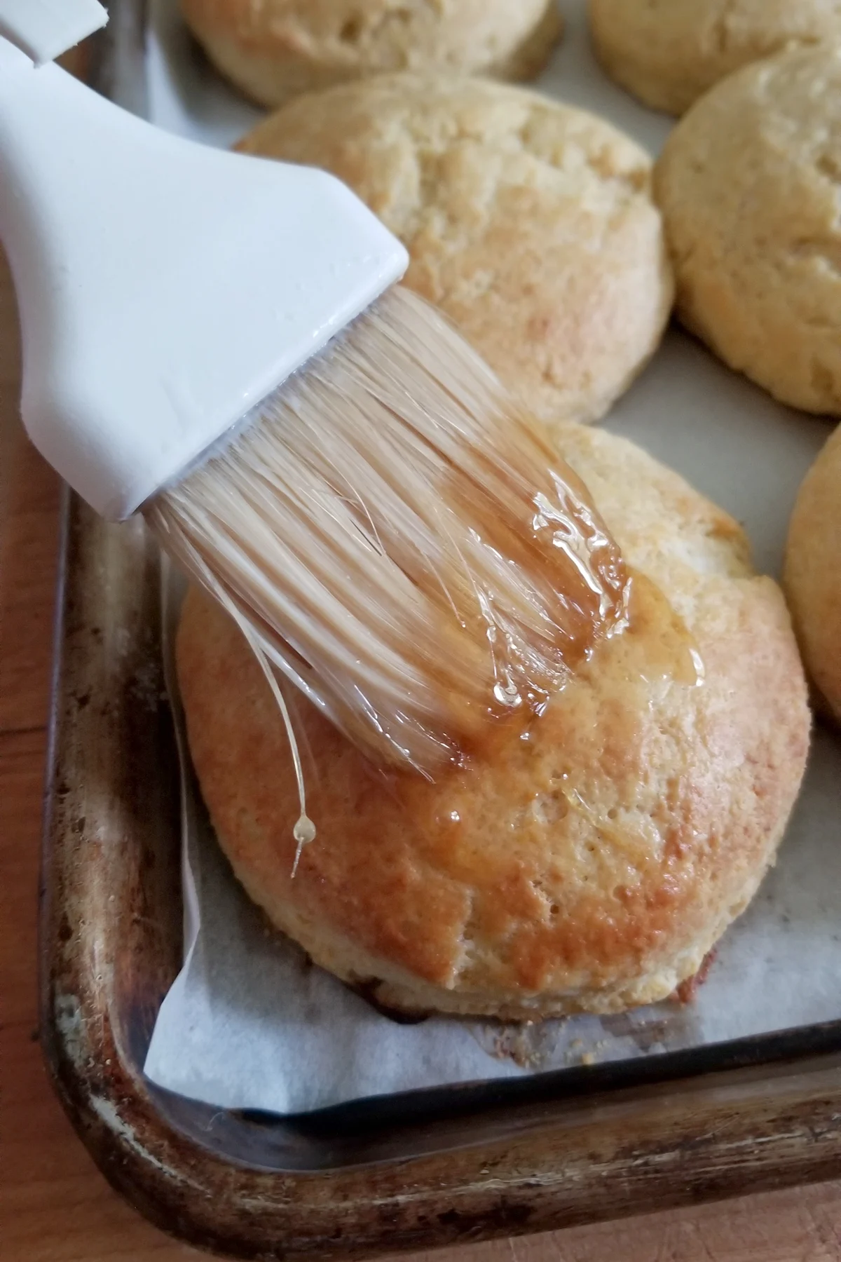 brushing honey on a biscuit