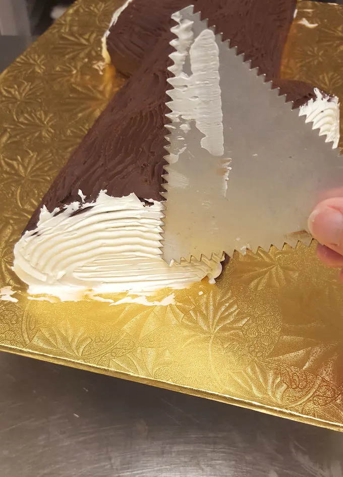 an icing comb forming texture on a yule log cake